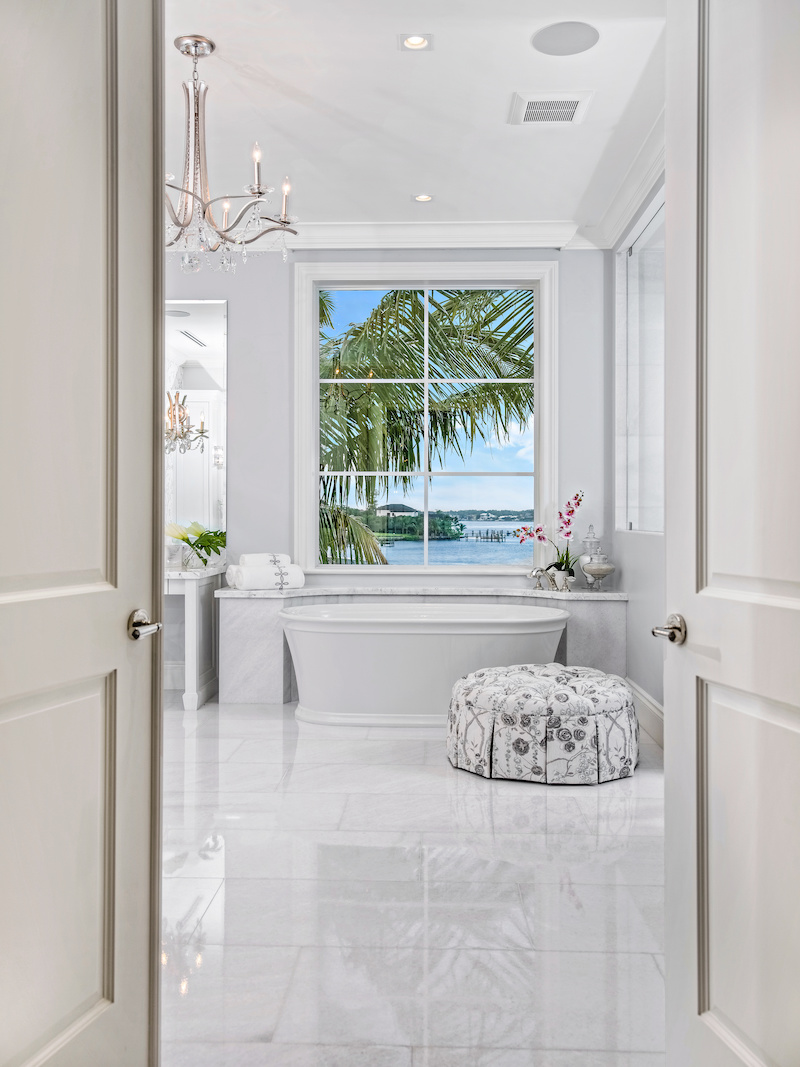 A grand, white marble bathroom featuring a Marvin Coastline Direct Glaze narrow frame window on a home in Jupiter, Florida.