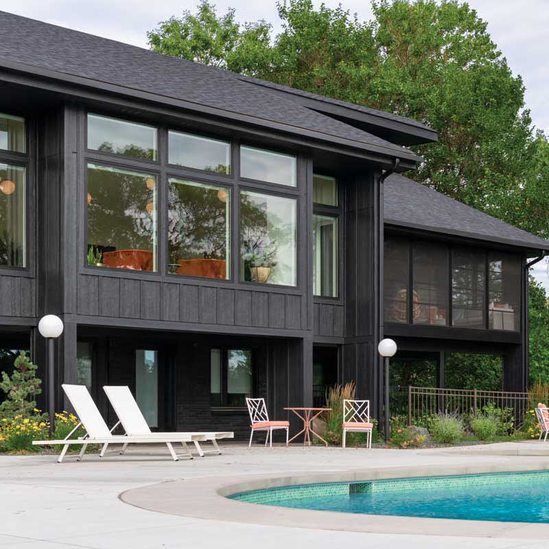 The back of a black home with pool featuring Marvin Essential Casement Picture and Awning windows.