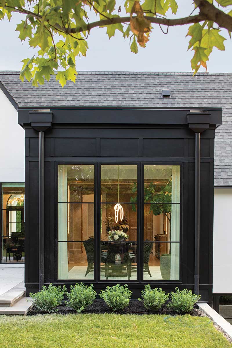 The exterior of a modern home looking through Marvin windows to a dining room.
