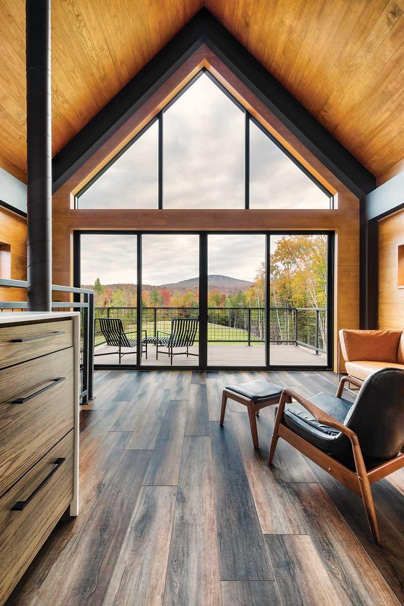 The interior of a modern home in Vermont overlooking Stratton Mountain through Marvin windows and a sliding door.