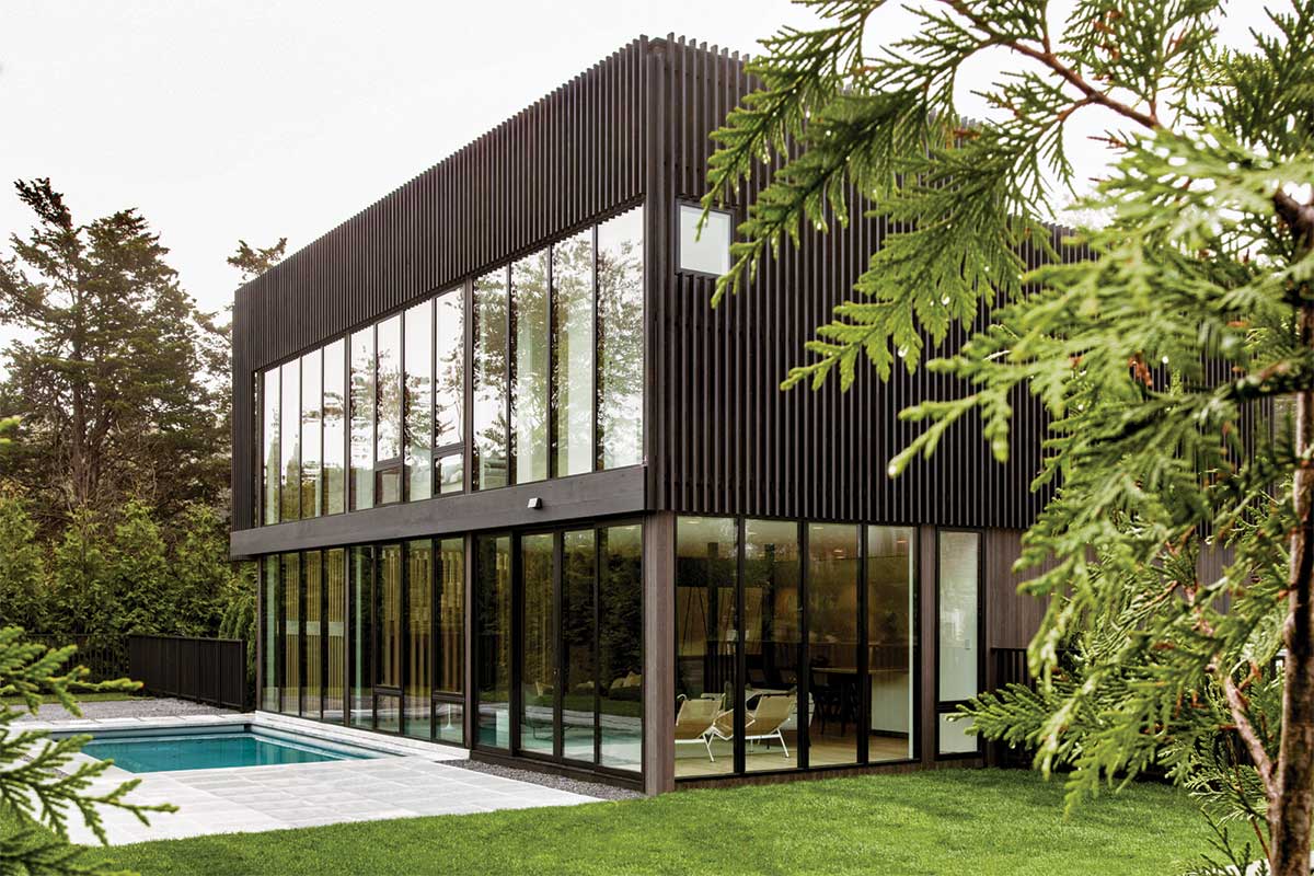 The exterior of a modern home in Sag Harbor, New York, featuring a pool and Marvin Modern windows and doors.