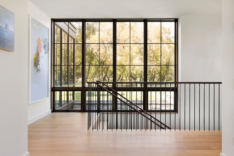 Floor-to-ceiling Marvin Ultimate Awning and Picture windows flank a Fargo home’s staircase.