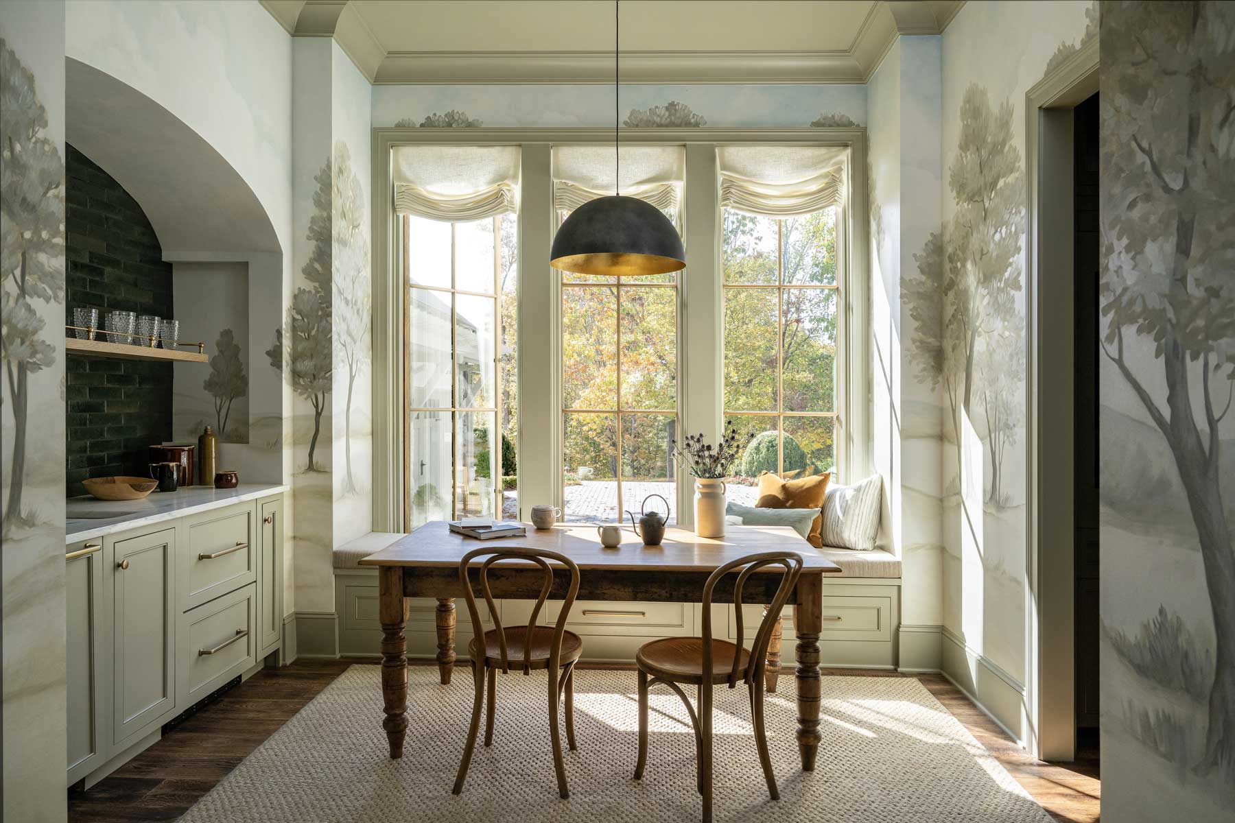 The breakfast nook inside the Southern Living Idea House 2023 with Marvin Ultimate windows and wallpaper with tall trees.