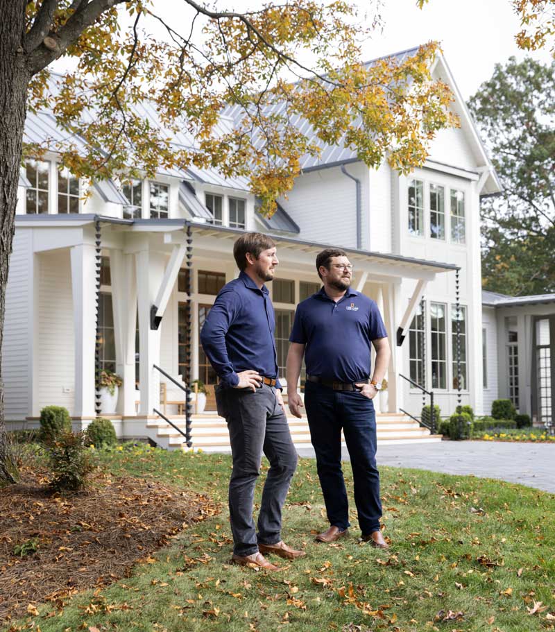 Resiential Designers, Luke Sippel and Bill Holloway of Lake + Land Studio, standing on the porch of the Southern Living Idea House 2023 in Leiper's Fork, TN.