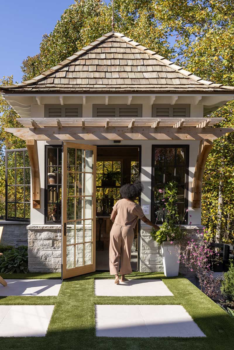 A woman walking into the garden folly outside the Southern Living Idea House 2023 in Leiper's Fork, TN.