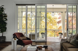 The great room of the Southern Living Idea House 2023 in Leiper's Fork, TN, featuring a Marvin Ultimate Multi-Slide door looking out to tall trees with fall colored leaves.