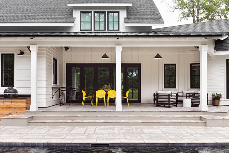 An exterior shot of a patio featuring black Marvin patio doors.