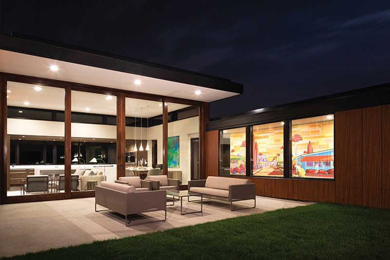 The exterior of a home at night featuring a Marvin Ultimate Lift and Slide door.