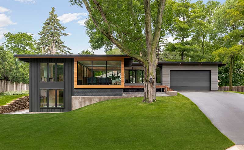A modern home set among trees features Marvin Modern windows and doors.