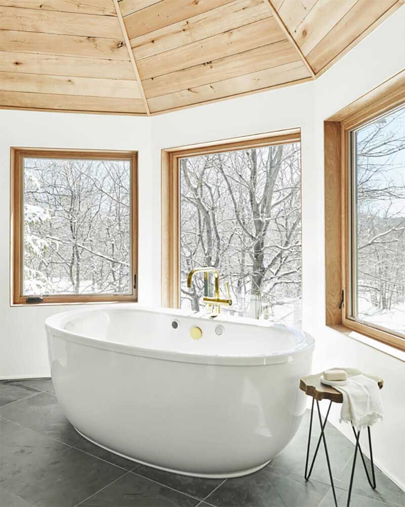Traditional style bathtub in front of set of 3 Marvin Windows