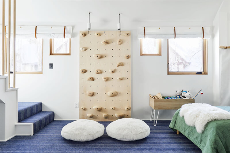 Large bedroom with rock climbing wall and multiple Marvin Windows