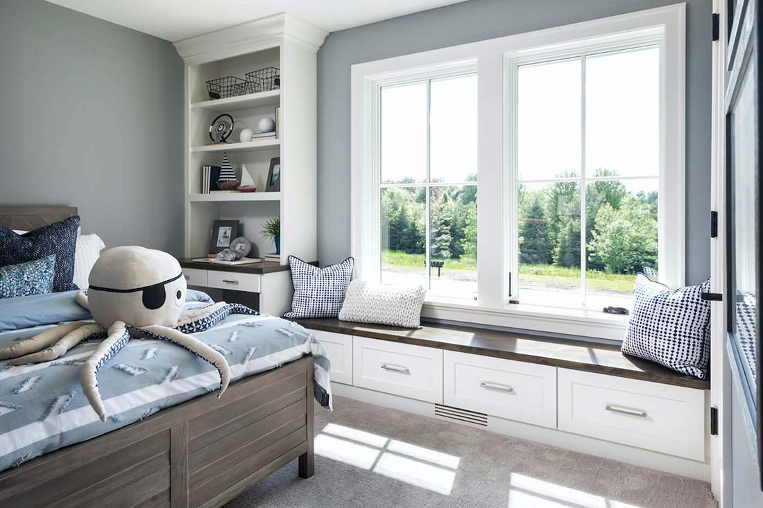 A bedroom featuring two casement windows and a window seat.