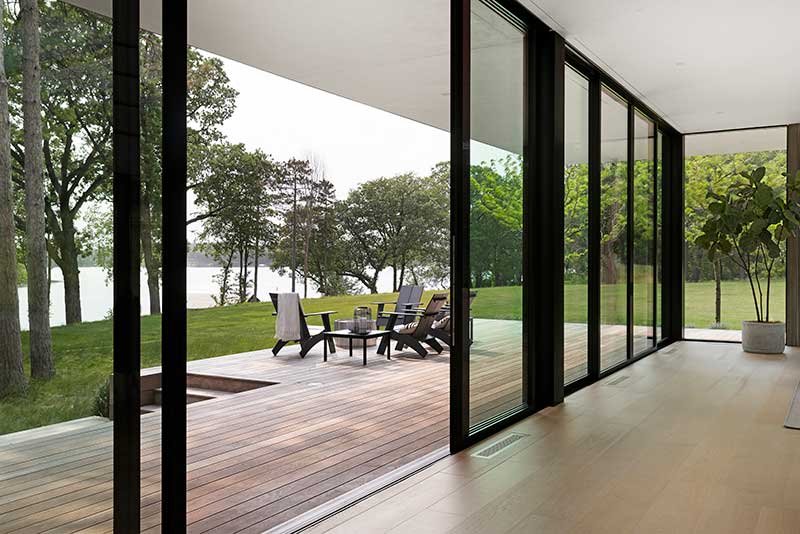 The view out to a patio through a Marvin Modern Multi Slide Door in a modern home on Lake Minnetonka.