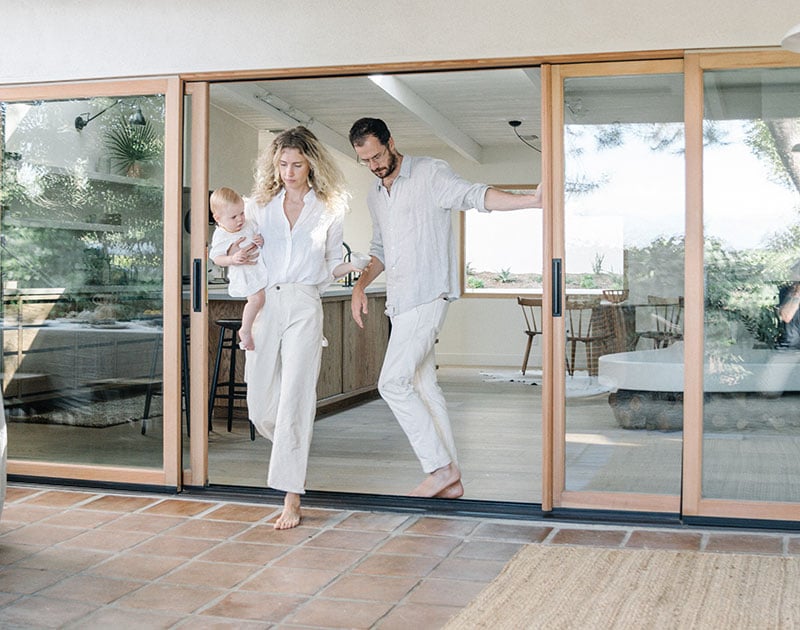 Amber Lestrange and her husband walking through their Marvin multi-slide patio door.