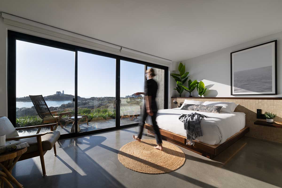 A room at the Viewpoint Hotel, featuring a Marvin Elevate Sliding Patio door overlooking a beautiful view of water.