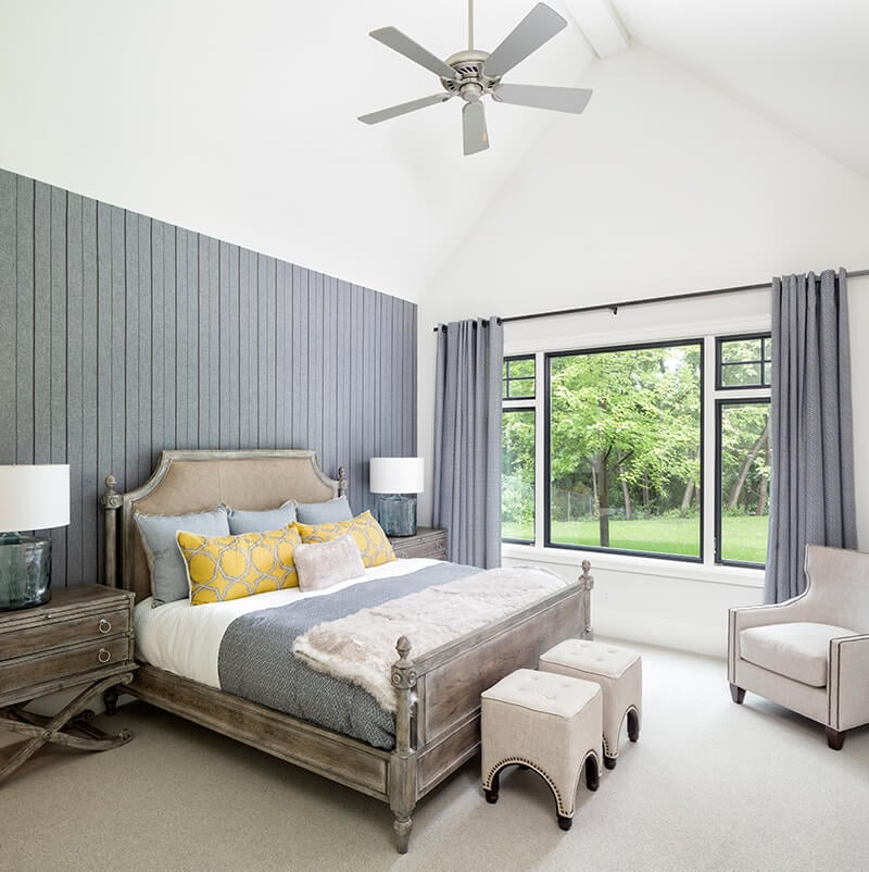A bedroom featuring a color palette of cool grays and pops of yellow.