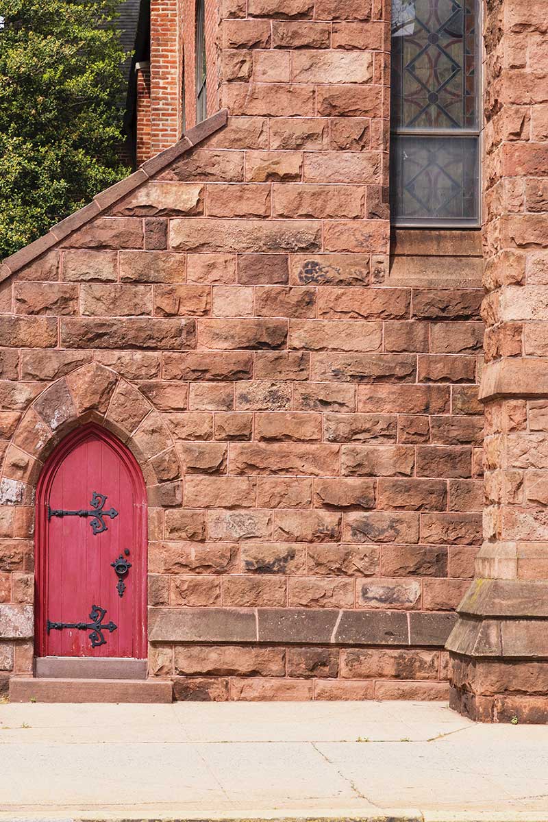 An arched red door on the exterior of Christ Episcopal Church in Reading, PA.