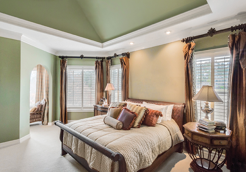 A bedroom is a grounding space to sleep, thanks to a painted ceiling and soothing light from Marvin Infinity Windows.
