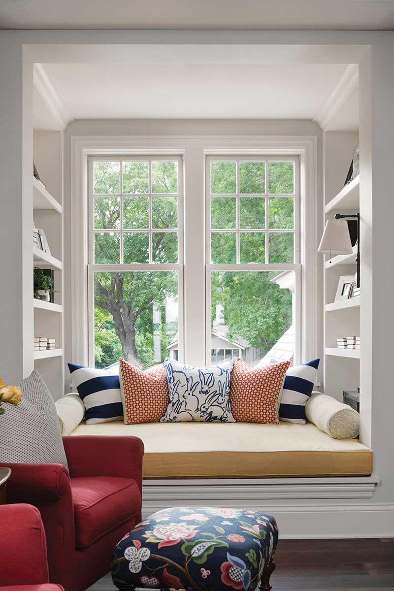 A window seat with built-in shelving and two Marvin double hung windows.