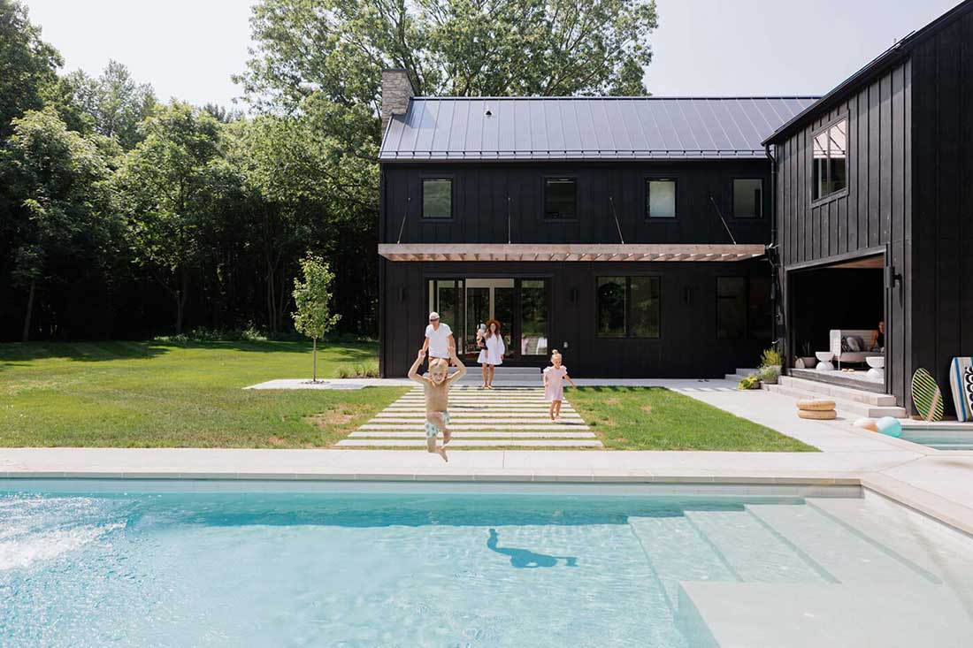 Pool front view of Danish Style Farmhouse home with Marvin windows