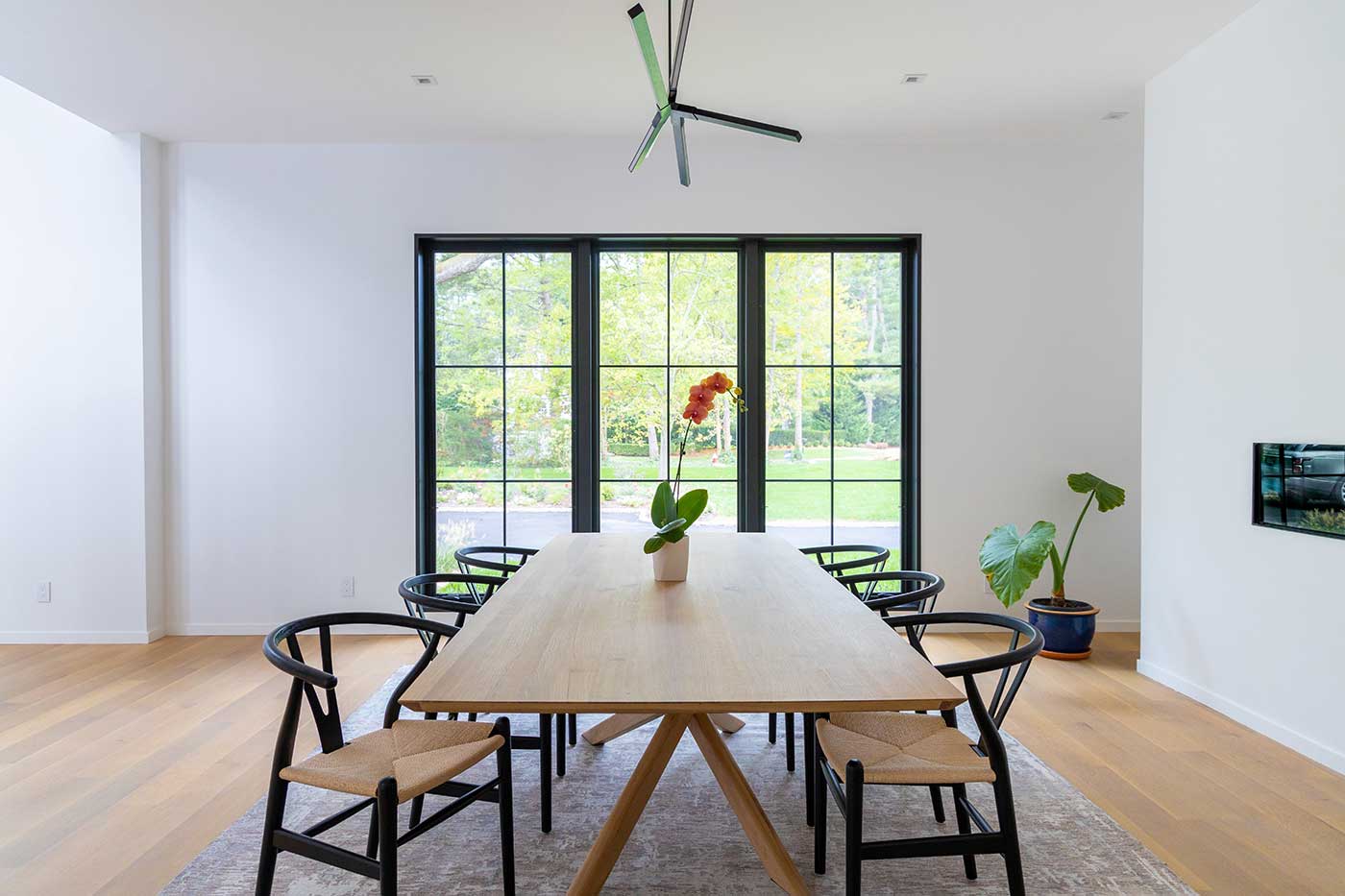 A modern dining room with black Marvin Signature Ultimate windows.