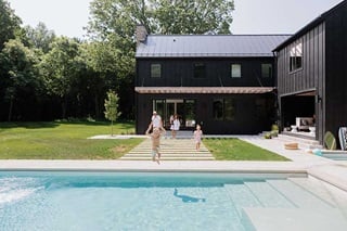 A family walking from their home to their backyard pool through a Marvin Elevate Sliding Patio door.