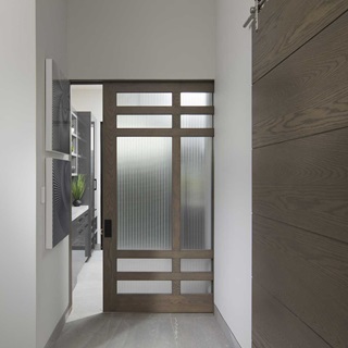 A TruStile pocket door with frosted glass panels that leads into a kitchen area.