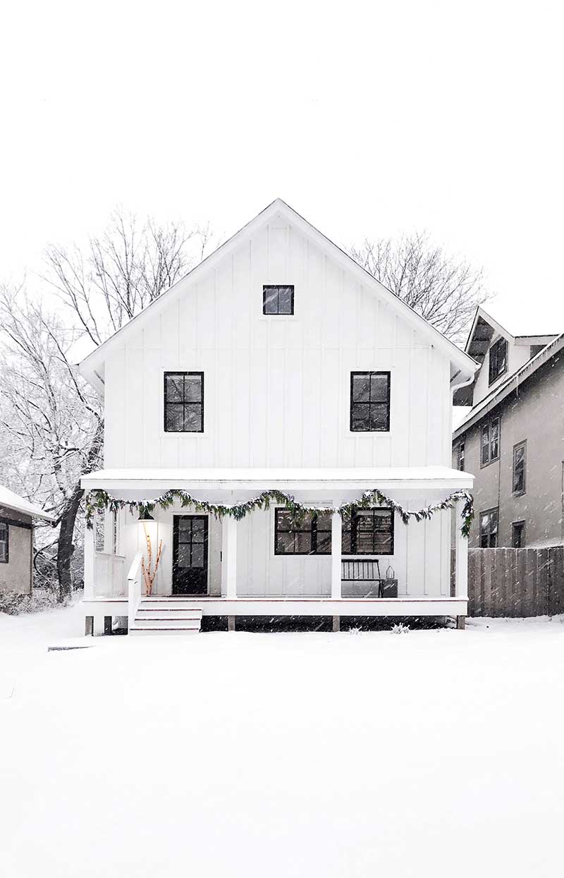 Melissa Coleman's white Minneapolis home in the wintertime with snow and holiday decorations.