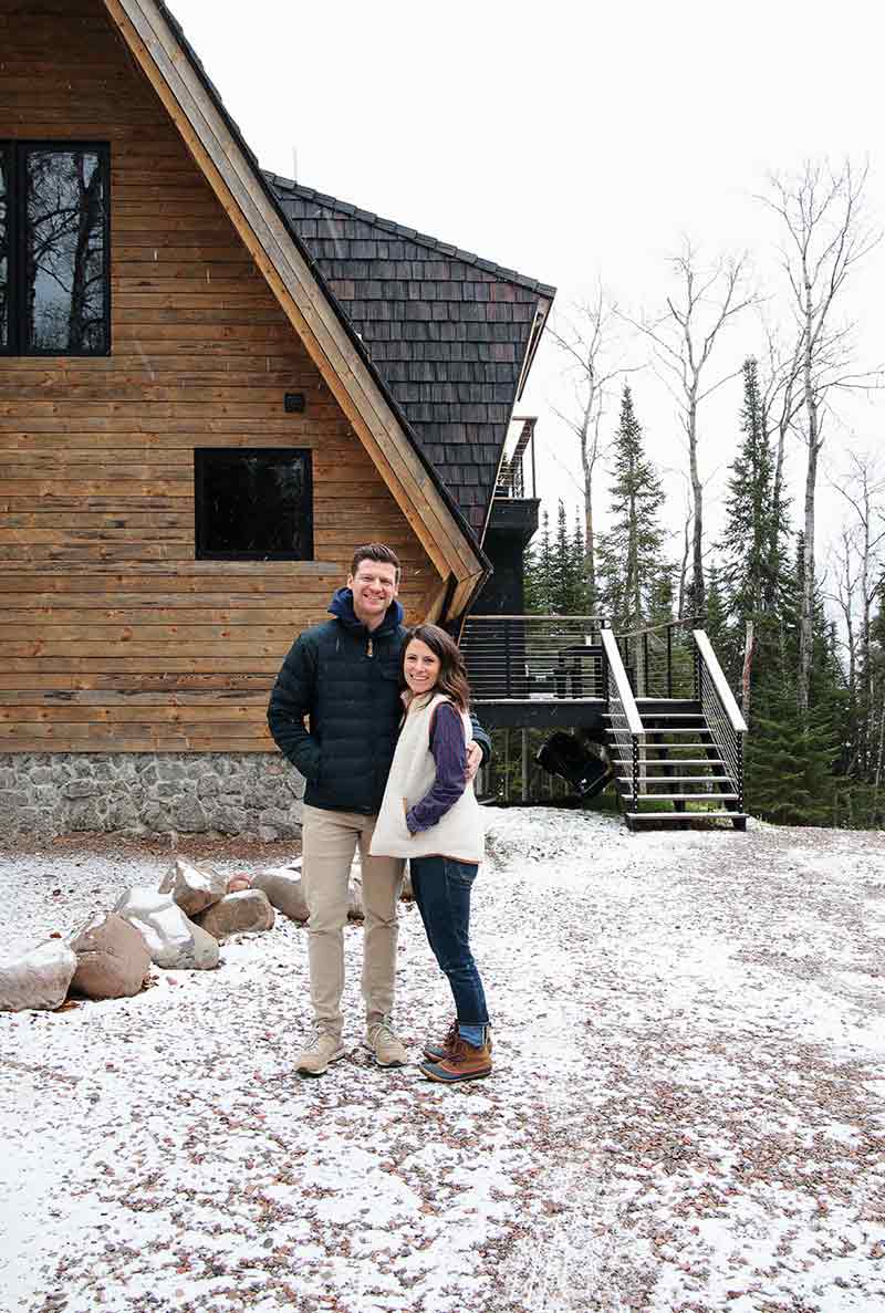 Melissa Coleman and her husband standing in front of their cabin, The Minne Stuga.