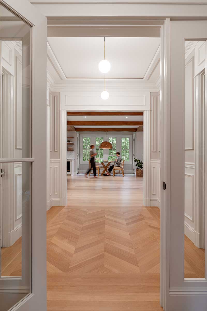 Two women in a dining area down a hallway through TruStile doors in the historic Hadley House.