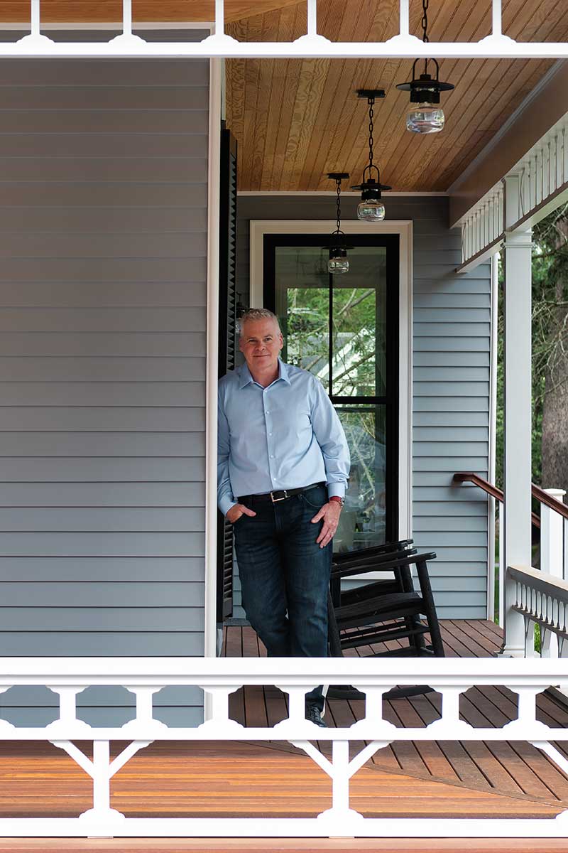 A portrait of Eric Gjerde on the porch of Hadley House in Wenham, Massachusetts, featuring Marvin windows and TruStile doors.