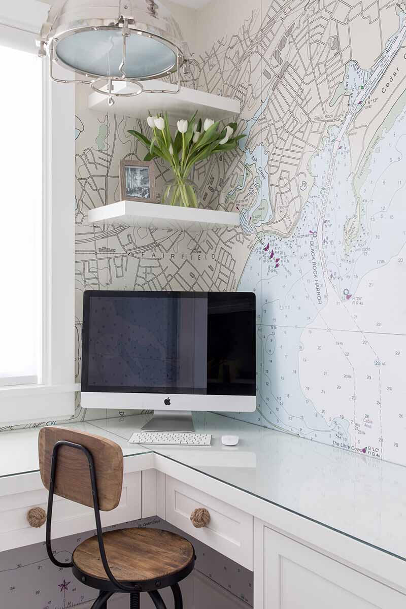 A corner desk with maritime map wallpaper.