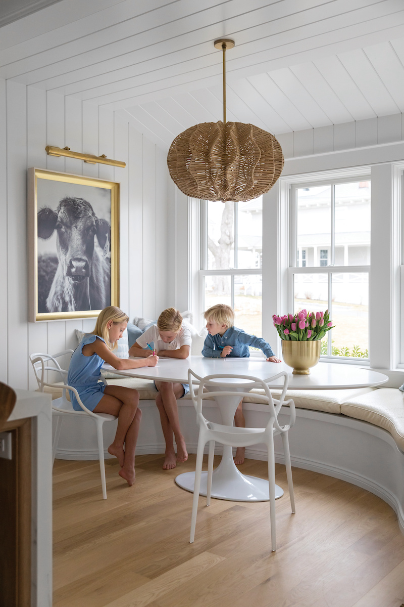 Three children sitting in a breakfast nook in their home in Hingham, Massachusetts.