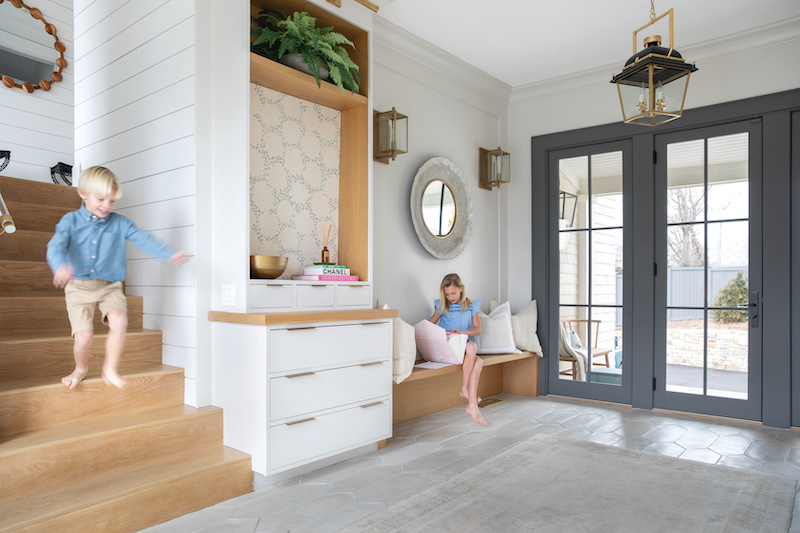 Two children playing in their home’s front entryway, featuring Marvin Elevate Inswing French doors.