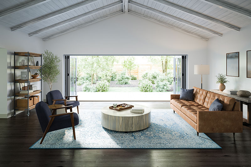 A modern living room with a large Marvin Bi-Fold Door looking out to green landscaping.