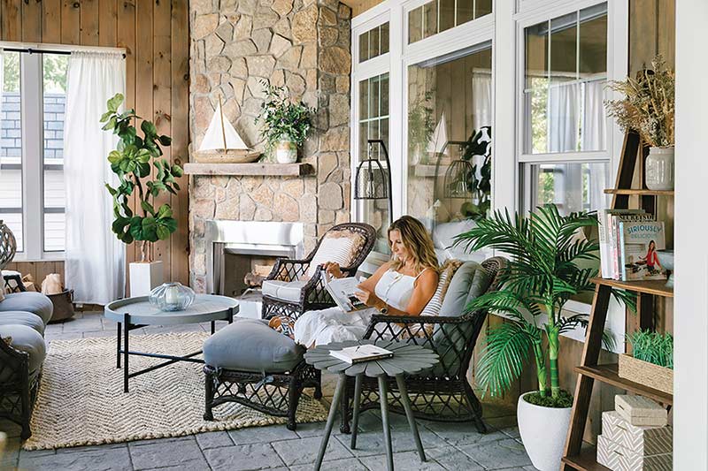 Real estate developer Tina DePalma sitting in her family room, surrounded by plants and natural light from Marvin windows.