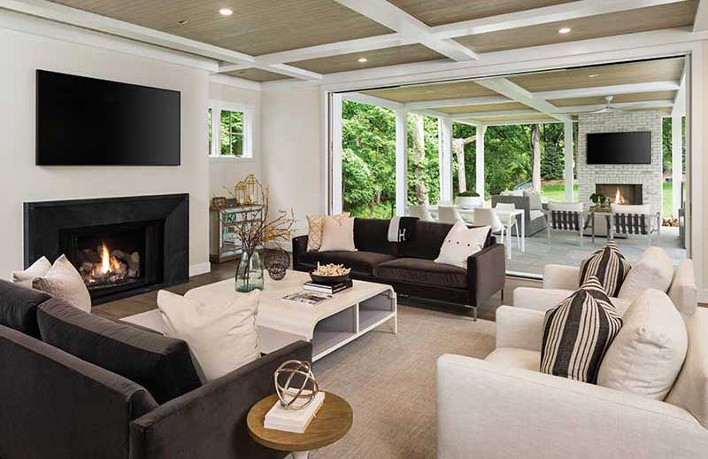 A Marvin Modern Multi-Slide door opens a modern home’s living room to an outdoor patio.