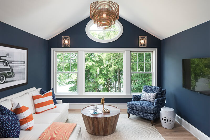 Living room with white double hung windows and navy walls.