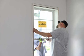 man looking at a replacement double hung window to find gaps.