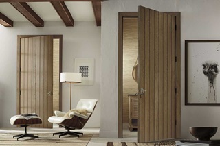 A sitting room next to a bathroom with TruStile doors and wood beams on the ceiling.