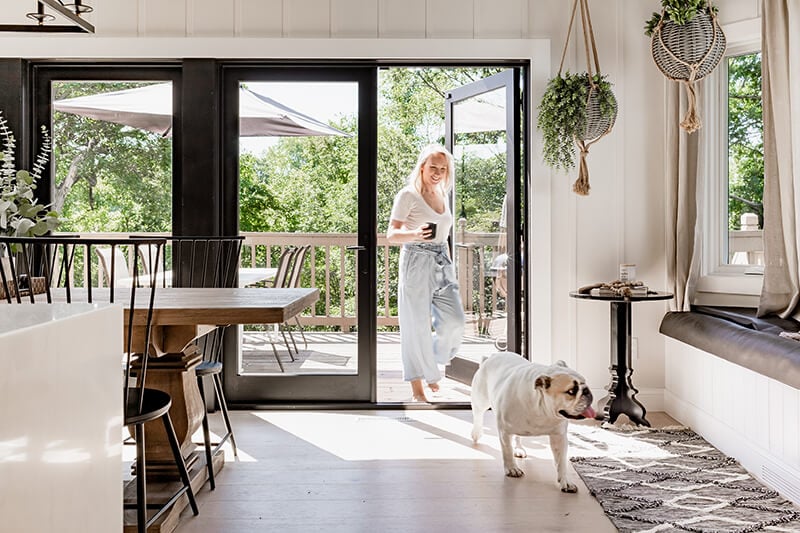 Katie Kurtz and the family bulldog in her redesigned kitchen featuring a Marvin Elevate Swinging French Patio Door.
