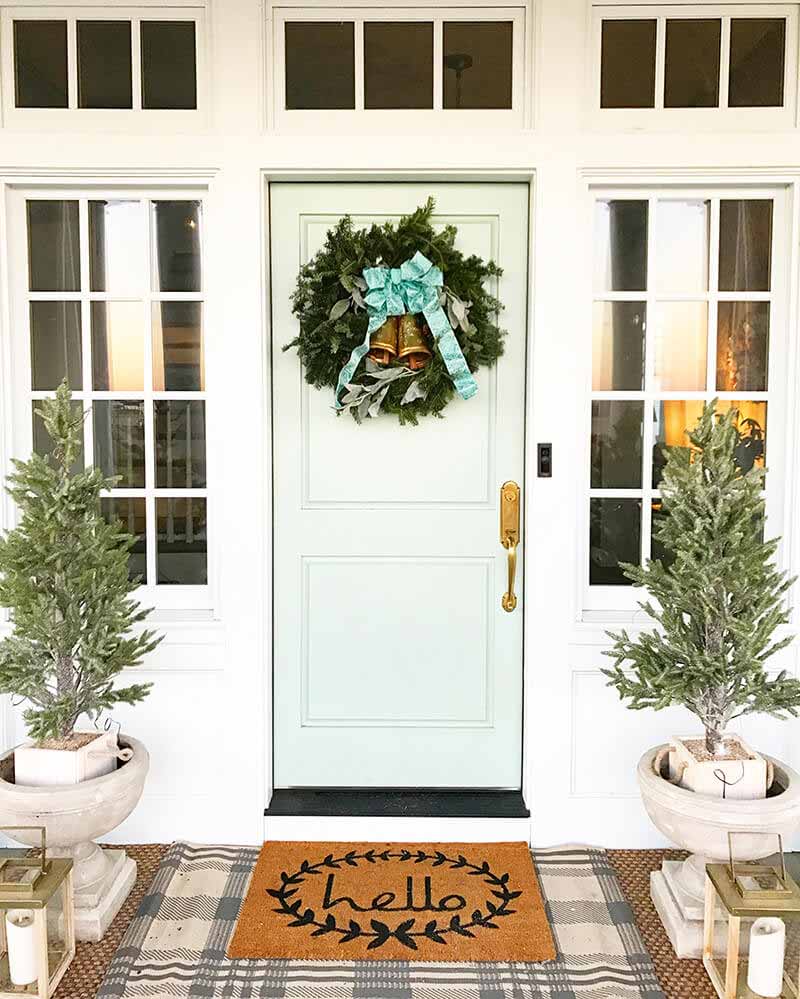 Front door of home with holiday decorations and multiple windows