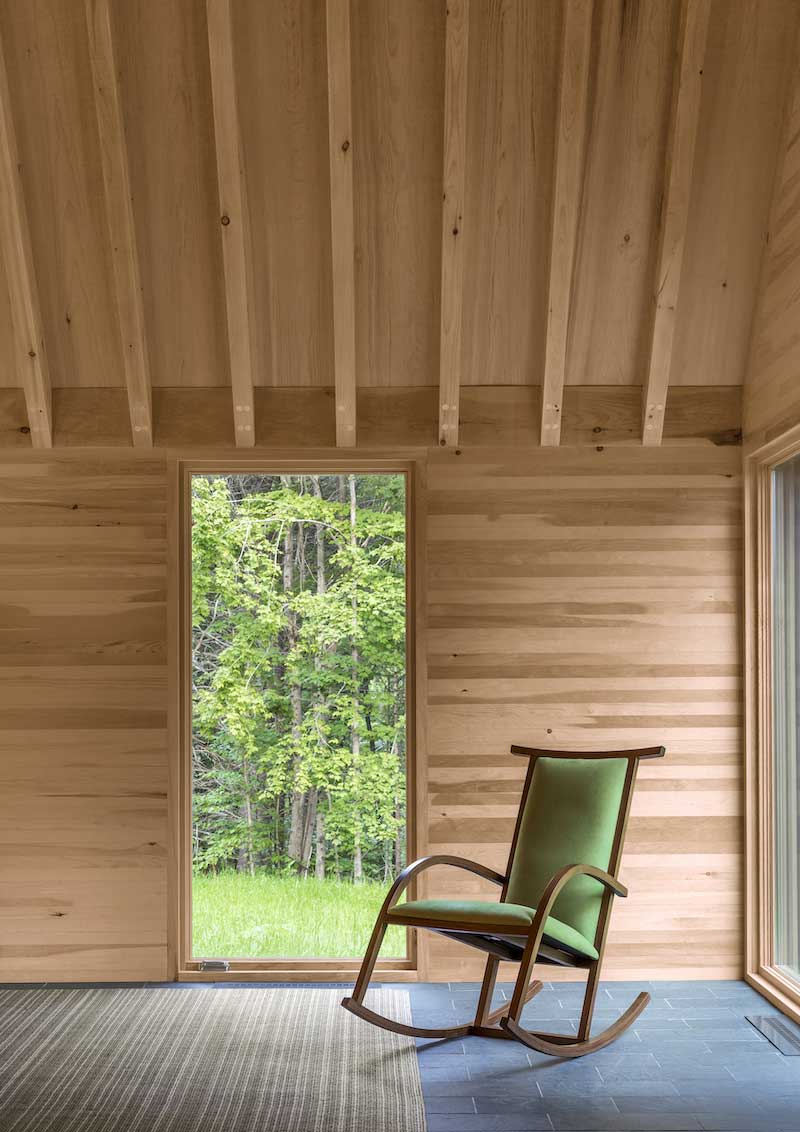 An interior photo of the Marlboro Music Cottages, featuring a Marvin Ultimate Casement window beside a rocking chair. 