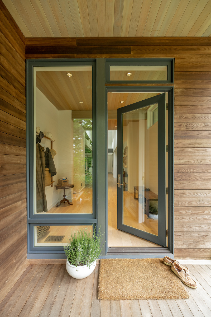 Wood-clad entryway to a Turkel prefab home in Martha’s Vineyard featuring Marvin Ultimate picture and awing windows and an Ultimate Inswing French door. 