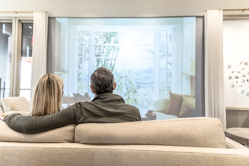 2 people on a couch looking through large Marvin Window