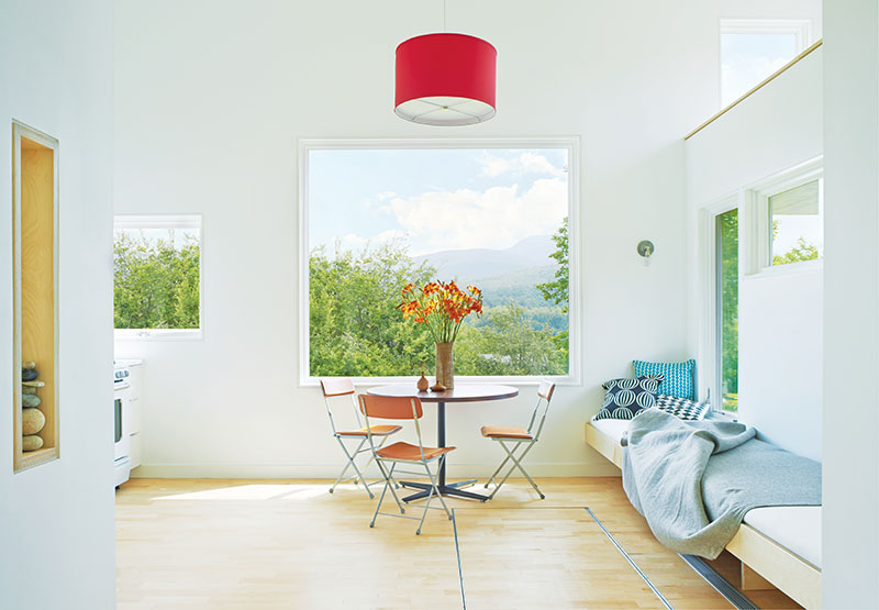 The eating and living area of a micro house in Vermont, featuring Marvin windows and doors.