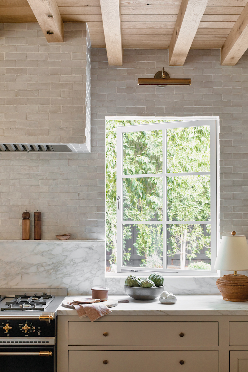 The kitchen in the personal home of Amber Lewis, of Amber Interiors, featuring Marvin windows.
