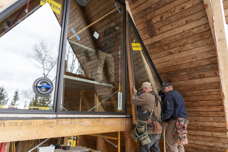 Two men installing Marvin Signature Ultimate Direct Glaze and Direct Glaze Polygon Windows at The Minne Stuga, an A-frame cabin in Grand Marais, MN.