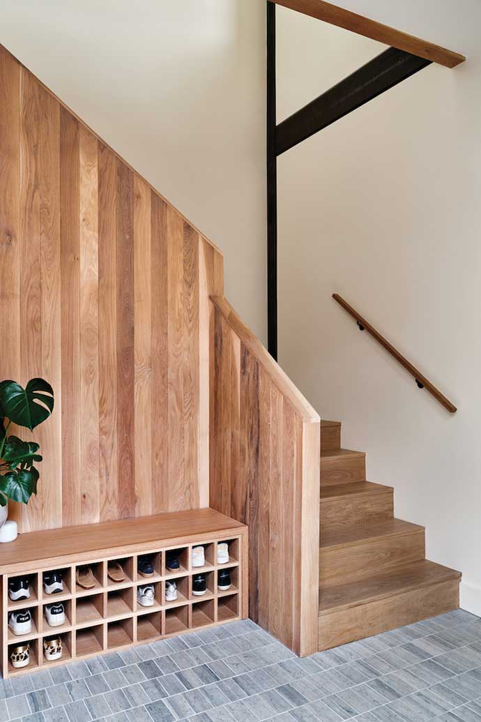 White oak staircase with built-in shoe rack in contemporary New Orleans home