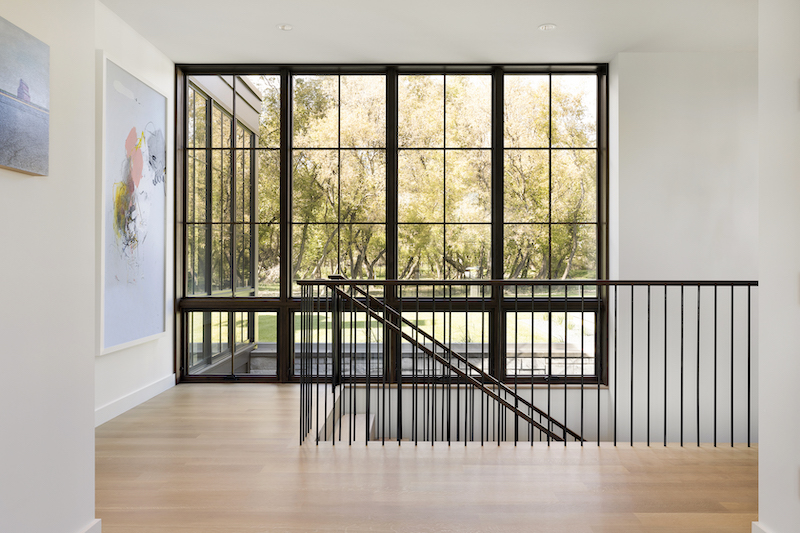 Floor-to-ceiling Marvin Ultimate Awning and Picture windows flank a Fargo home’s staircase.